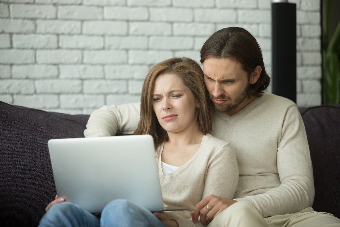 Couple frowning at laptop